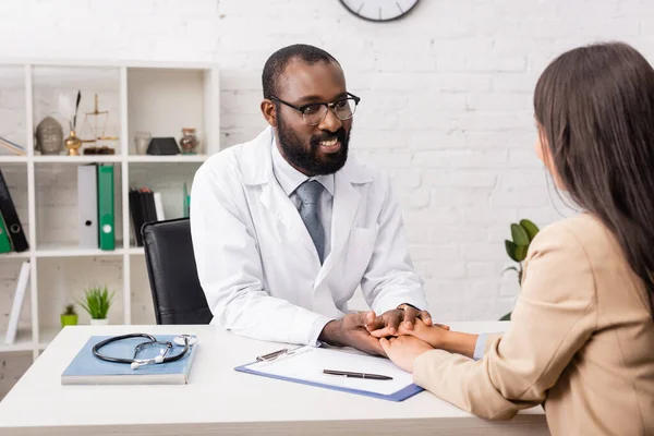 African American Doctor Eyeglasses Touching Hands Brunette Patient Clipboard Insurance — Stock Photo, Image