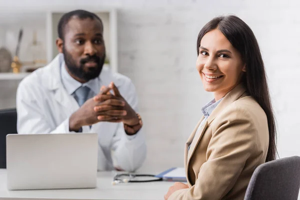 Enfoque Selectivo Paciente Alegre Mirando Cámara Cerca Médico Afroamericano — Foto de Stock