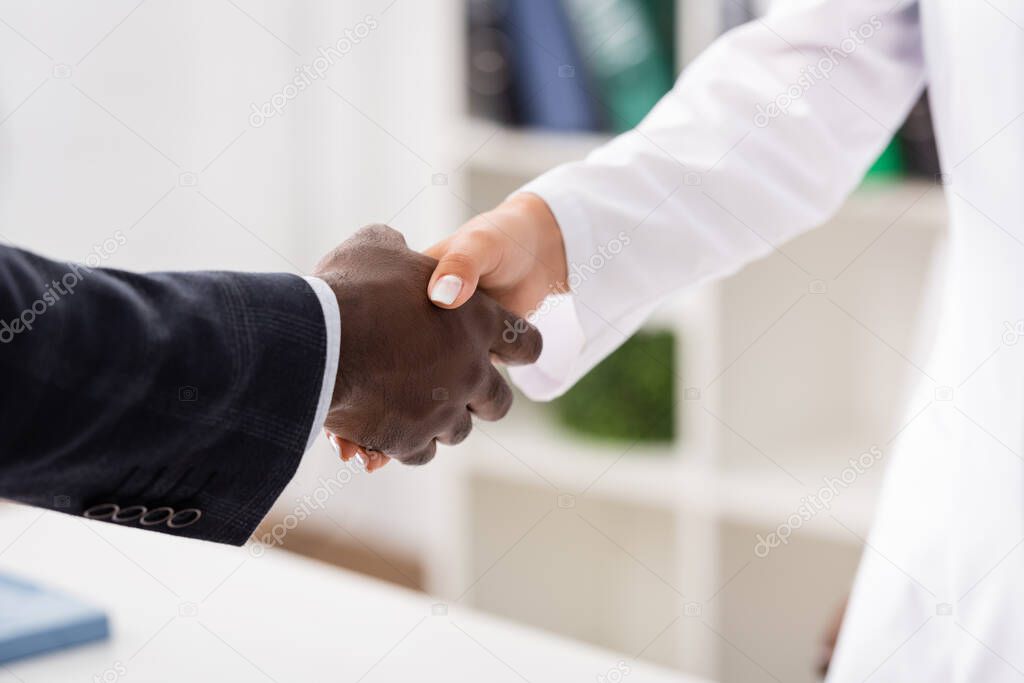 cropped view of african american patient shaking hands with doctor