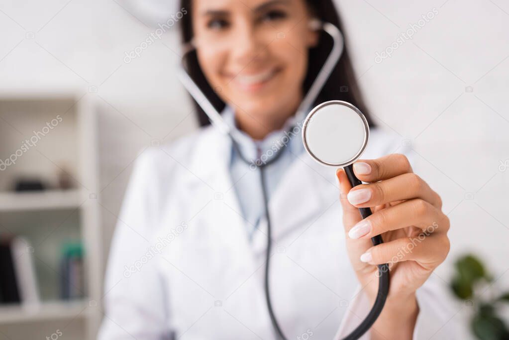 selective focus of joyful doctor holding stethoscope in hospital