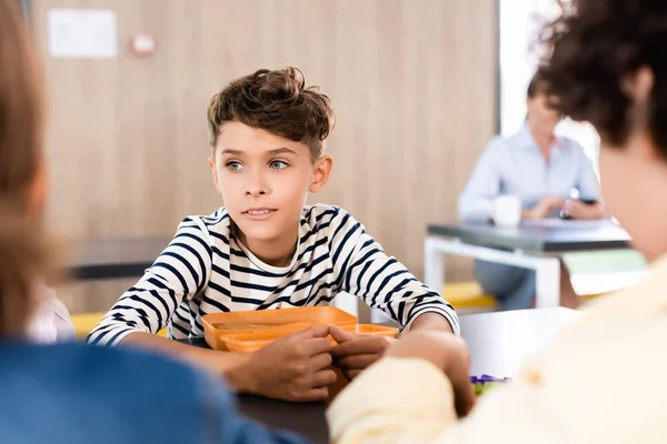 同級生の近くの学校の食堂に座っている少年の選択的な焦点 — ストック写真