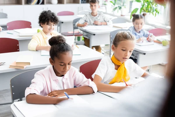 Enfoque Selectivo Los Alumnos Multiculturales Que Escriben Cuadernos Durante Lección — Foto de Stock