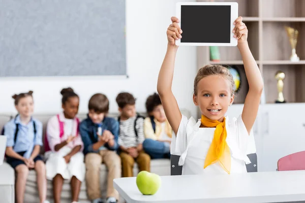 教室で机の上にアップルの近くにデジタルタブレットを示す女子高生と多民族のクラスメートの選択的な焦点 — ストック写真