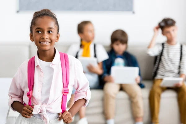 Selective Focus African American Schoolgirl Touching Backpack Friends Background Classroom — Stock Photo, Image