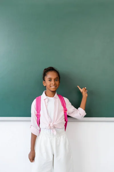 African American Schoolgirl Pointing Finger Chalkboard Classroom — Stock Photo, Image