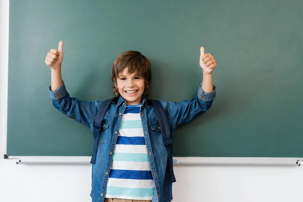 Schoolboy Σακίδιο Δείχνει Τους Αντίχειρες Κοντά Στο Πράσινο Chalkboard — Φωτογραφία Αρχείου