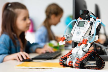 Kök okulda bilgisayar kullanarak öğrencilerin yakınındaki robotların seçici odak noktası 