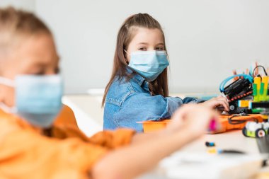 Tıp maskeli öğrencilerin seçici odak noktası kök okulda robot üretmeleri. 