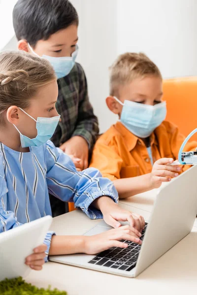 Enfoque Selectivo Los Niños Multiculturales Máscaras Médicas Utilizando Gadgets Mientras — Foto de Stock