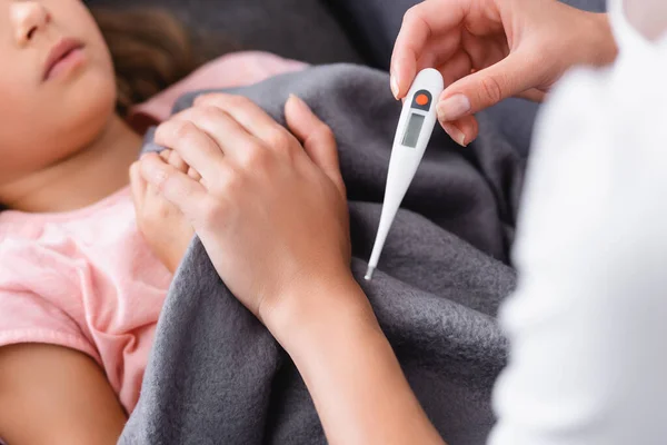 Vista Recortada Mujer Sosteniendo Termómetro Tocando Niño Sofá — Foto de Stock