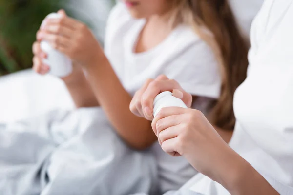 Foco Seletivo Mulher Segurando Frasco Com Pílulas Perto Filha Cama — Fotografia de Stock