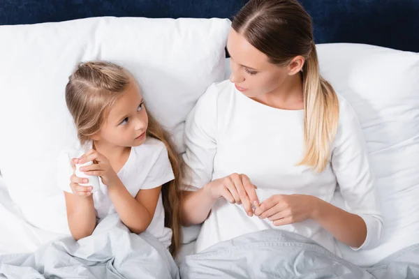 Nézi Gyermeket Miközben Tartja Üveg Tabletták Ágyon — Stock Fotó