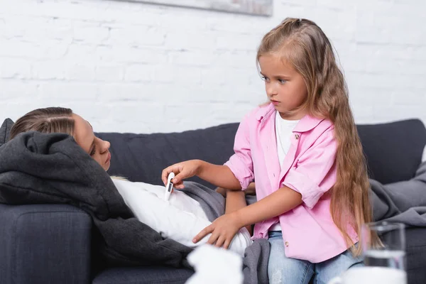 Selective Focus Child Holding Thermometer Mother Lying Couch — Stock Photo, Image