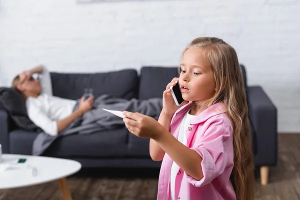 Selective Focus Girl Holding Thermometer While Talking Smartphone Sick Mother — Stock Photo, Image