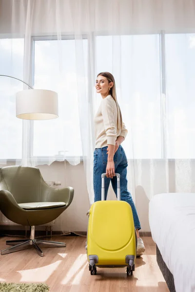 Młoda Kobieta Stojąca Żółtym Bagażem Pokoju Hotelowym — Zdjęcie stockowe