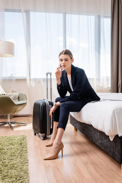 Young Businesswoman Suit Talking Smartphone While Sitting Bed Baggage Hotel — Stock Photo, Image