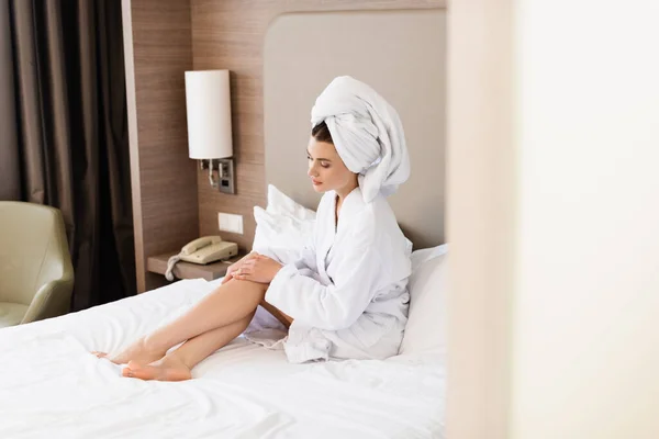 Wybiórcze Skupienie Kobiety Boso Ręczniku Białym Szlafroku Siedzącej Łóżku Dotykającej — Zdjęcie stockowe