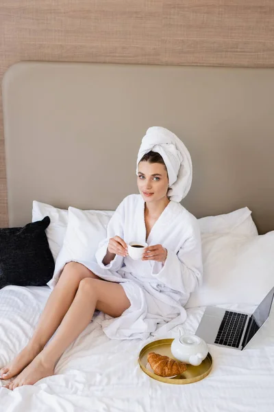 Jovem Mulher Roupão Segurando Xícara Café Perto Laptop Bandeja Café — Fotografia de Stock