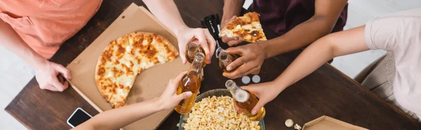 Ostříhaný Pohled Multikulturních Přátel Cinkajících Láhvemi Piva Pizzy Během Párty — Stock fotografie