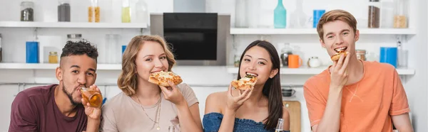 website header of joyful multiethnic friends eating pizza during party