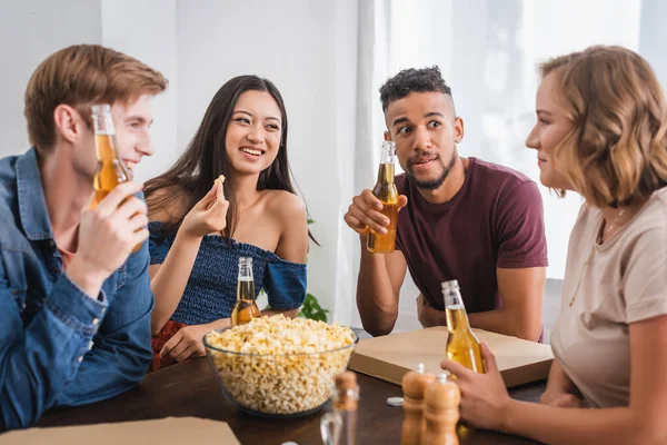 Amigos Multiculturales Hablando Mientras Sostienen Botellas Cerveza Cerca Tazón Con — Foto de Stock