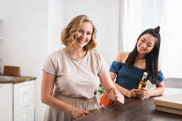 Joyeuse Femme Ouverture Bouteille Bière Près Asiatique Ami Pendant Partie — Photo