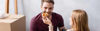 panoramic concept of woman feeding boyfriend with tasty pizza clipart