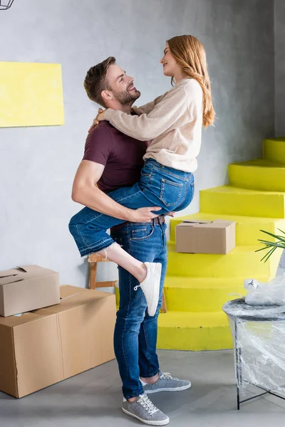 Homem Segurando Nos Braços Olhando Para Namorada Alegre Nova Casa — Fotografia de Stock
