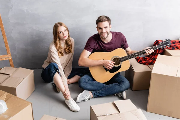 Jonge Vrouw Zitten Vloer Met Man Spelen Akoestische Gitaar Buurt — Stockfoto