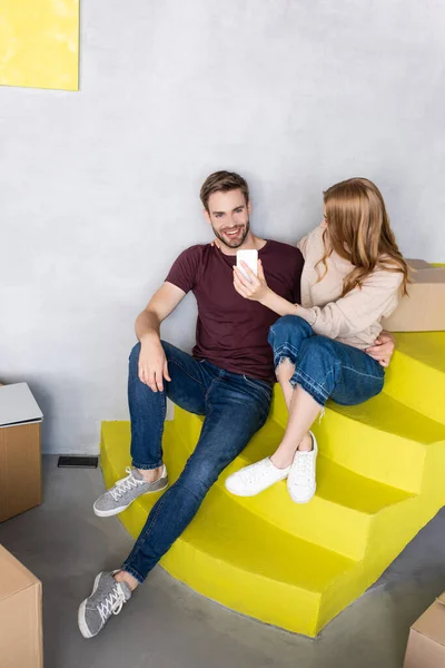 Joyful Man Sitting Yellow Stairs Using Mobile Phone Carton Boxes — Stock Photo, Image