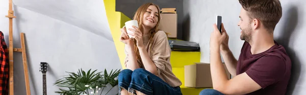 Horizontales Bild Eines Fröhlichen Mannes Der Freundin Mit Tasse Fotografiert — Stockfoto