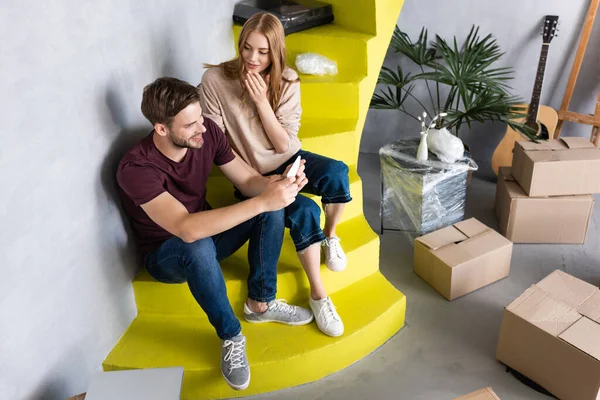 Man Using Smartphone While Sitting Stairs Girlfriend Carton Boxes — Stock Photo, Image