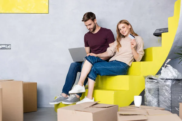 Young Woman Holding Credit Card Man Using Laptop Sitting Yellow — Stock Photo, Image