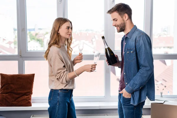 Hombre Satisfecho Pie Con Mano Bolsillo Celebración Botella Cerca Mujer — Foto de Stock