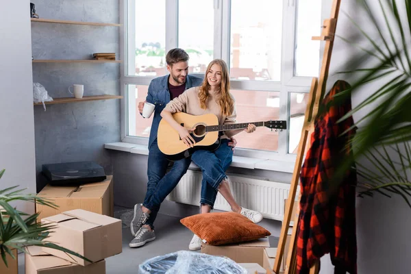 Foco Seletivo Jovem Tocando Guitarra Acústica Perto Homem Caixas Papelão — Fotografia de Stock