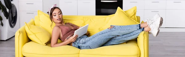 Panoramic Orientation Woman Lying Yellow Couch Digital Tablet — Stock Photo, Image