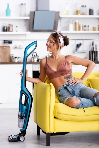 Ama Casa Con Mano Cadera Sentada Sofá Amarillo Mirando Hacia — Foto de Stock