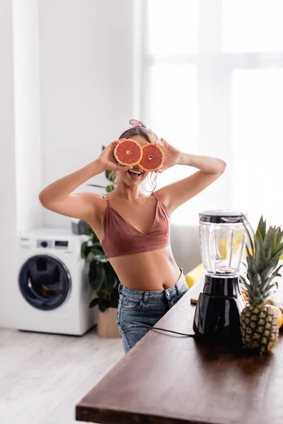 Enfoque Selectivo Mujer Cubriendo Cara Con Mitades Pomelo Cerca Licuadora — Foto de Stock