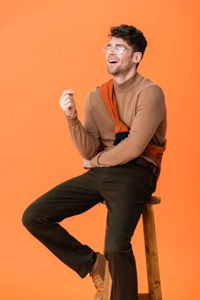 Opgewonden Man Herfst Outfit Bril Zitten Houten Kruk Lachen Oranje — Stockfoto