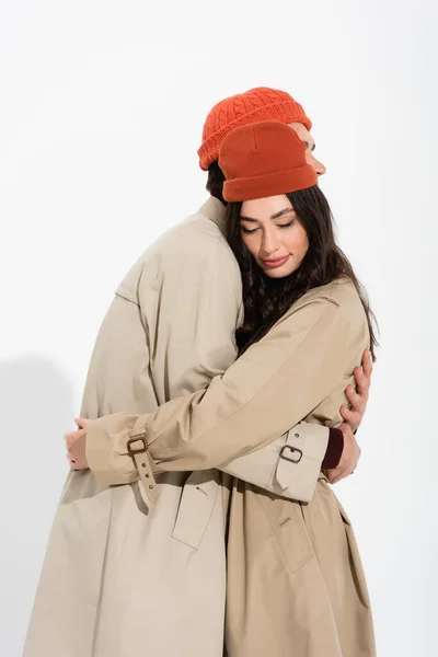 Stylish Couple Beanie Hats Trench Coats Hugging White — Stock Photo, Image