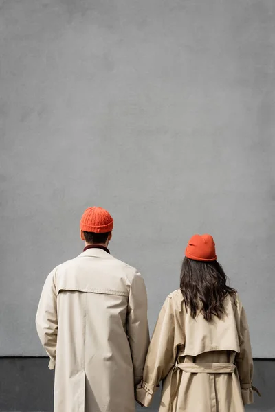 Back View Couple Trench Coats Hats Standing Grey Wall — Stock Photo, Image