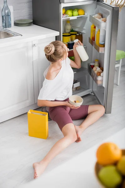 Blonde Young Woman Holding Bowl Cornflakes Bottle Milk While Sitting — Stock Photo, Image