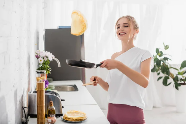 Freudige Junge Frau Weißen Shirt Wirft Beim Frühstück Pfannkuchen Auf — Stockfoto