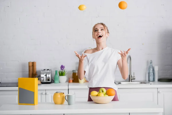 Mujer Joven Emocionada Haciendo Malabares Con Frutas Frescas Mientras Está — Foto de Stock