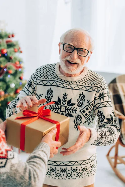 Επιλεκτική Εστίαση Της Ευτυχισμένος Ηλικιωμένος Λαμβάνοντας Χριστουγεννιάτικο Δώρο Από Σύζυγο — Φωτογραφία Αρχείου