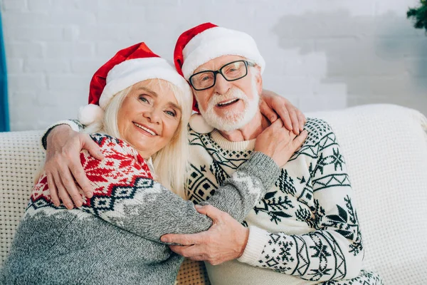 Happy Senior Couple Santa Hats Embracing While Looking Camera — Stock Photo, Image