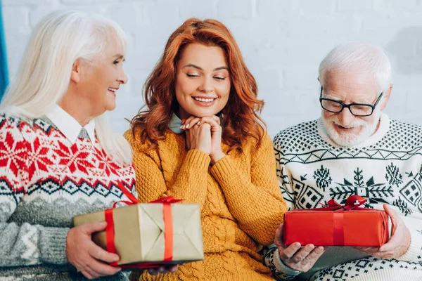 Κατάπληκτη Γυναίκα Κάθεται Κοντά Ηλικιωμένους Γονείς Κρατώντας Χριστουγεννιάτικα Δώρα — Φωτογραφία Αρχείου