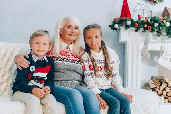 Happy Senior Grandmother Embracing Grandchildren While Sitting Sofa Together — Stock Photo, Image