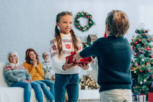 Back View Boy Presenting Christmas Gift Happy Sister Relative Sitting — Stock Photo, Image