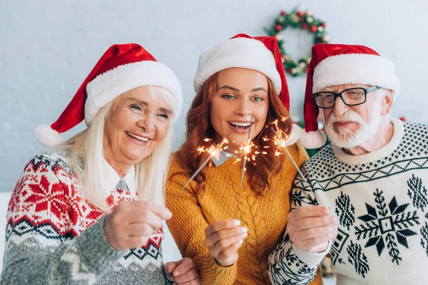 Radostný Starší Pár Dcerou Santa Klobouky Držení Jiskřičky Vánoce — Stock fotografie